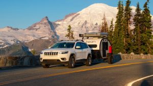 A tear drop trailer being towed by an SUV
