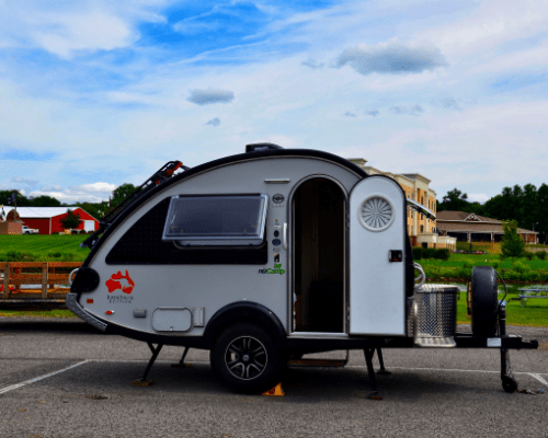 tear drop trailer parked with door open.